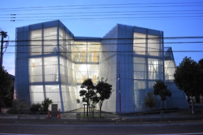夜はエキスパンドメタルを通して室内の光が漏れる。図書館は午前９時～午後５時（祝日・休日を除く（火）（水）は８時まで）。（金）、第３（木）休み。