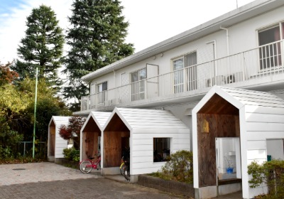 各棟に三角屋根の玄関と駐輪場が二つずつ。改修前の玄関が「暗くて怖い」という子供たちの声に応え、ドアは透明樹脂製 
