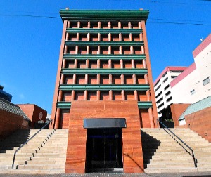 イラン産の赤い大理石や、緑青加工の銅板を使ったファサード